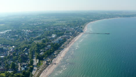 Wonderful-aerial-drone-view-of-Baltic-sea-coast-shoreline-in-Scharbeutz,-Germany,-circle-pan,-sunny-summer-day